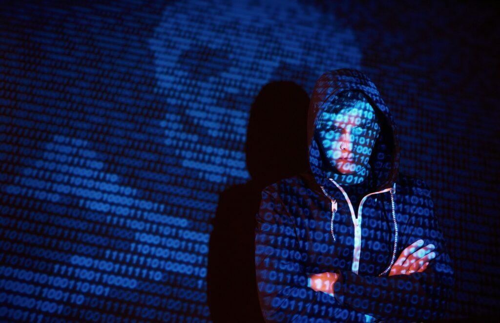 Cyber attack with unrecognizable hooded hacker using virtual reality, digital glitch effect